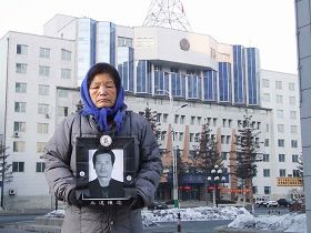 李龙吉七十二岁的母亲手捧老伴的遗照