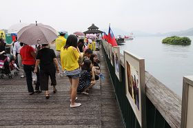 伊达邵码头上的游客正专注观看法轮功真相图片