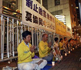 法轮功学员在中联办正门外点起烛光，悼念被迫害致死的中国大陆同修。