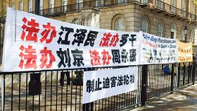 '李长春访英，法轮功学员在英国首相府对面展开横幅抗议中共迫害'