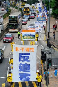 法轮功学员张起“和平理性反迫害”的大幡，行经香港的主要金融经济区。