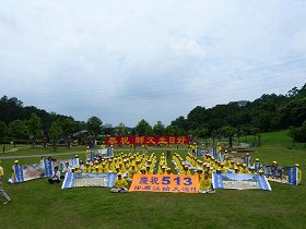 '中坜全体学员于十二日上午在大溪慈湖纪念雕塑公园合影，并向李洪志师父问候生日好。'