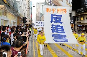 '素琴（左侧第一位）参加五月六日香港反迫害游行时，掌“反迫害”大旗。'