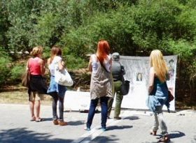 '希腊学员在雅典的卫城博物馆旁举办信息日活动。不少游人驻足观看，了解法轮功真相。'