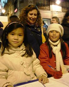 一位女士与自己领养的两个中国女孩一同签名支持法轮功