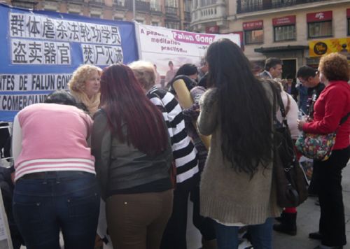 西班牙民众及游客观看中共迫害法轮功学员的展板图片