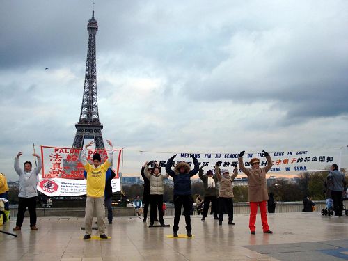 '法国部份法轮功学员来到埃菲尔铁塔旁的巴黎人权广场，进行了炼功、讲真相'