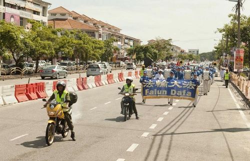 '天国乐团在警方和志愿警卫团（RELA）协助开路下，在槟城北海游行'