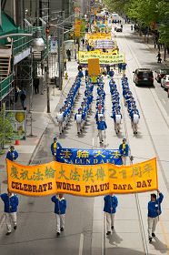 多伦多法轮功学员及各界人士在多伦多市区游行，庆祝法轮大法洪传二十一周年。
