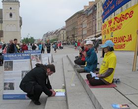 古城广场上游客在反对中共迫害法轮功的征签簿上签名