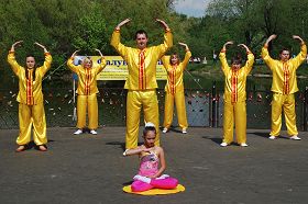 法轮功学员们身穿金黄色的服装展示了五套功法