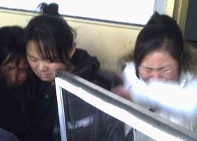 图：二零一一年二月，在佳木斯监狱，秦家妻女见到秦月明遗体痛苦万分。