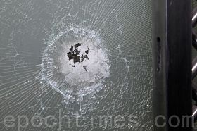 '被暴徒砸损的香港大纪元印刷厂玻璃大门'