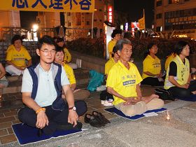 '图2，立法委员刘建国（左一）与法轮功学员并肩悼念默哀'