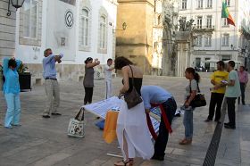 Coimbra的民众看真相展板和演示<span class='voca' kid='86'>功法</span>，签名支持反迫害