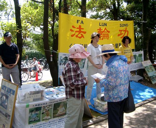图2：学员们在第十八届稻泽夏季活动节展位上向市民介绍法轮功