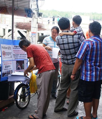 法轮功学员在马国吉胆岛村口的讲真相征签行动引起民众的关注