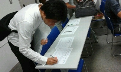 与会者在呼吁制止中共活摘法轮功学员器官的签名纸上签字