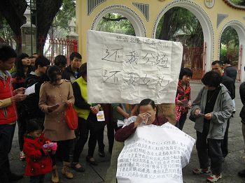 上图：邓彩娟的母亲在向众人述说女儿遭受的迫害