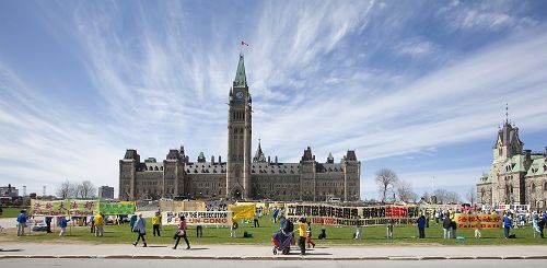 二零一四年五月七日，法輪功修煉者在加拿大首都國會山前，慶祝法輪大法洪傳世界二十二周年。