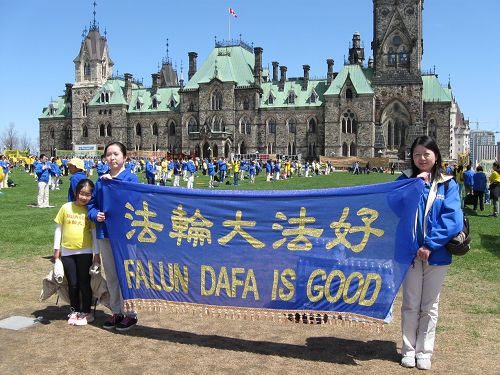 法輪功學員邱楠楠（右）和兩個女兒在集會現場。