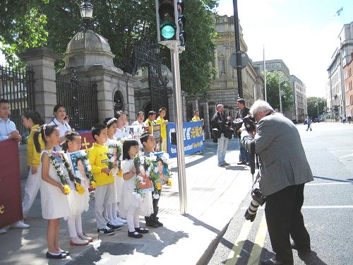 图1：爱尔兰法轮功学员的游行队伍在爱尔兰议会大楼门前暂留，爱尔兰主流媒体报纸的摄影记者给游行队伍拍照。