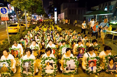 台湾高雄法轮功学员在人潮密集、陆客喜爱的高雄巨蛋、瑞丰观光夜市和明诚公园间举办“七•二零烛光夜悼会”
