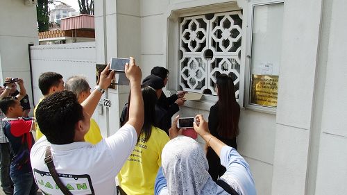 法轮功学员递交抗议信于中共驻马大使馆，引起了许多警官的关注。