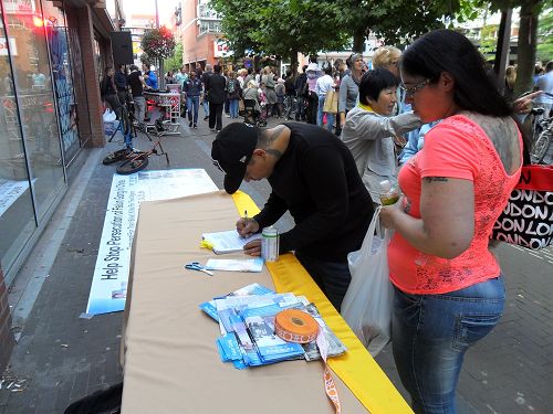 人们纷纷签名支持法轮功学员信仰自由的权利