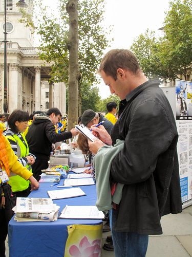 图7：二零一五年十月十日，在剑桥大学教法律的约翰（John）在伦敦圣马丁广场签名谴责中共活摘罪行，他还表示让更多的人听到全球公审江泽民的信息非常重要