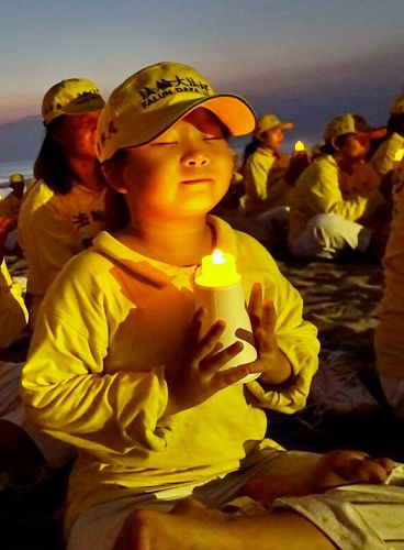 图：印尼学员在海滩上举行烛光悼念活动，悼念在中国被中共迫害致死的法轮功学员