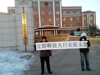张玉堂、关日安家属要求立即释放，在看守所门前举牌抗议照片。