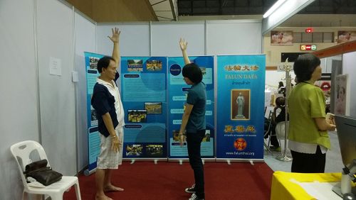 泰国健康与美容展上，参观者向法轮功学员学炼功法