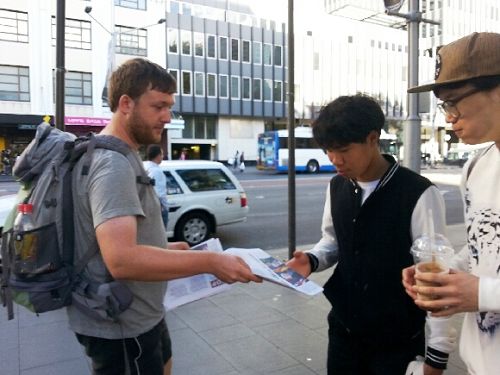 德国游客菲尔（Phil，左）主动派发揭露中共活摘器官的真相资料给路人