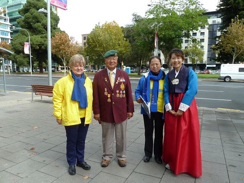 澳纽军团日游行的韩裔老兵Yun Lee支持法轮功，和学员合影。