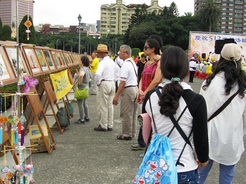 图4-8：法轮功正法之路图片展吸引游客驻足观看。