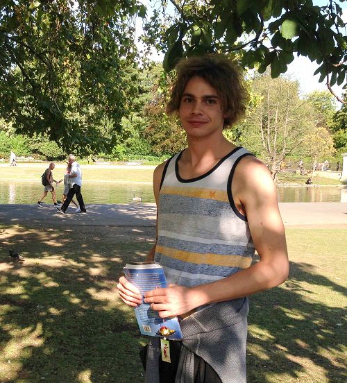 二零一五年八月二十二日，羅馬青年麥克在英國倫敦攝政公園法輪功煉功點第一次學煉法輪功，手拿義大利版的《法輪功》和法輪功學員製作的手工蓮花，高興地笑了