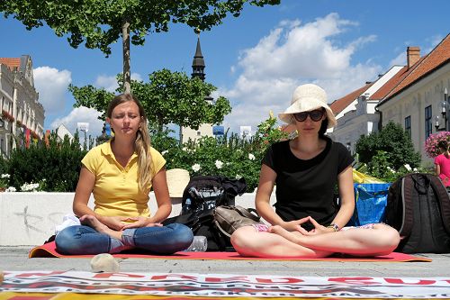 法轮功学员在特尔纳瓦市真相展位前打坐