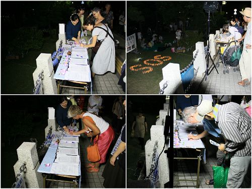 烛光守夜活动中，人们在继续签名支持法轮功