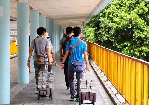 图2：台湾青年学子们一大早就拉着各种法轮功真相材料推车搭火车到景点街头派发并且讲真相。