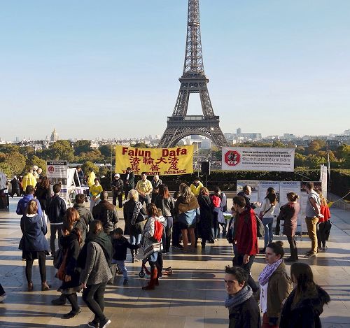 '图1：巴黎人权广场上游人驻足了解法轮功真相'