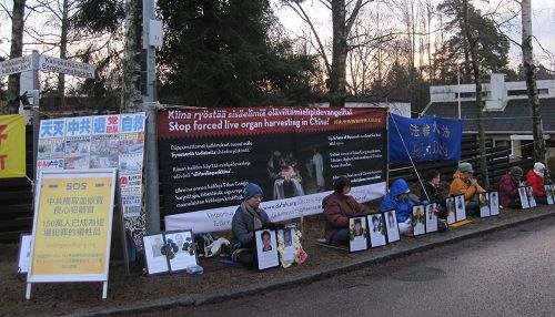 '图1、法轮功学员在中共驻芬兰使馆前抗议中共迫害'