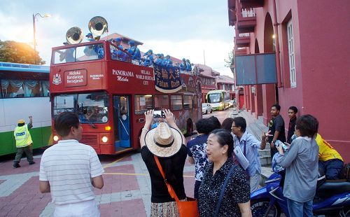中国游客惊喜民众开心看到天国乐团在荷兰红屋广场演奏，抓紧时间拍照、摄影留念。