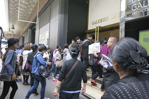 法轮功学员在拉法耶特商场门前向大陆游客们赠发真相资料。