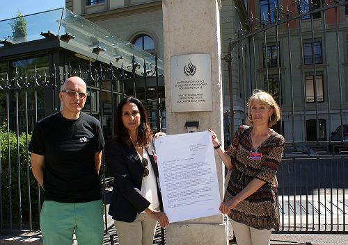 图3：瑞士日内瓦州大议会议员马克•法尔盖（左）和瑞士法轮功学员Barthia女士（中）、Orlandini女士（右）在联合国高级人权专员办事处门前展示议员们的联名信。