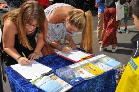 两位年轻女士在征签表上签名，支持法轮功学员。