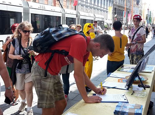 奧地利格拉茨市中心，路人簽名支持法輪功反迫害