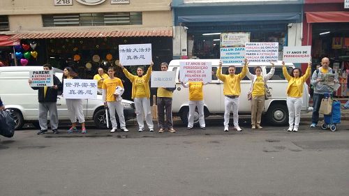 '图5：在圣保罗25街的活动，法轮功学员打着横幅，举着展板，呼吁中共停止迫害法轮功'