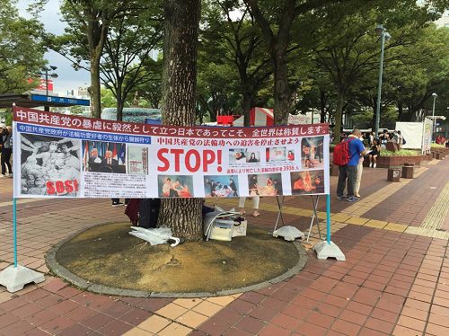 '图1：法轮功学员在日本名古屋繁华街边一角，挂起了反迫害的条幅'