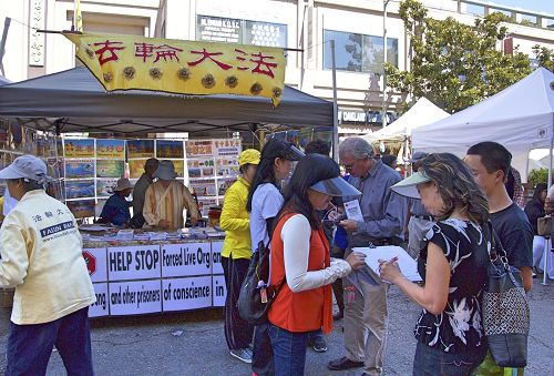 '图1-2：加州旧金山湾区法轮功学员在奥克兰市一年一度的中秋街会设立展位，向民众传播法轮功真相。许多民众主动签名支持法轮功学员反迫害。'